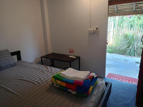 a bedroom with a bed and a table and a window at Maloop Cafe Bungalow in Koh Rong Island