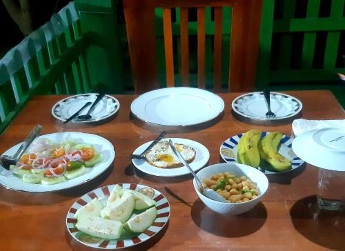 a table with plates and bowls of food on it at Jm Resort in Dambulla