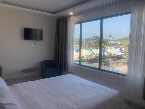 una camera d'albergo con un letto e una grande finestra di Hà Hùng Panorama Hotel a Hà Tiên