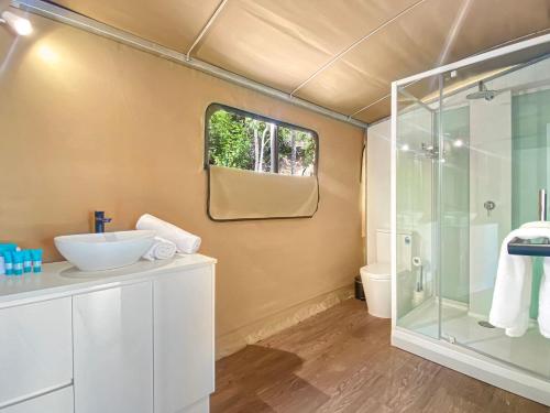 W łazience znajduje się umywalka i przeszklony prysznic. w obiekcie Magnetic Glamping Tent 3 w mieście Nelly Bay