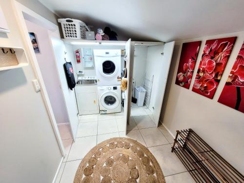 a small laundry room with a washer and dryer at Unique Estuary & Bird Apartment in Te Haumi Paihia in Paihia