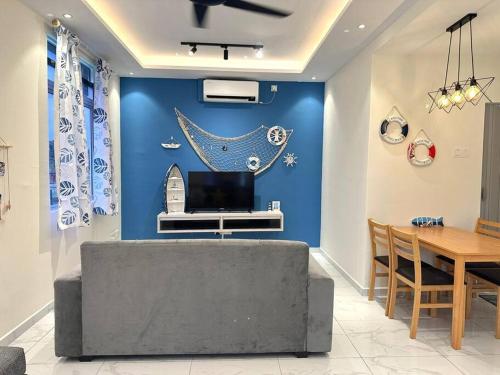 een woonkamer met een blauwe muur en een tafel bij Blue Ocean House 3br DatoOnn JB in Johor Bahru