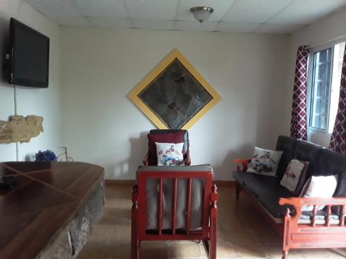 a living room with two chairs and a couch at Casita Villa el sol in Alto Boquete