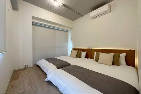 1 dormitorio con 2 camas y ventana en bHOTEL Art Bldg - Modern 2BR City Center for 8ppl en Ōsukachō