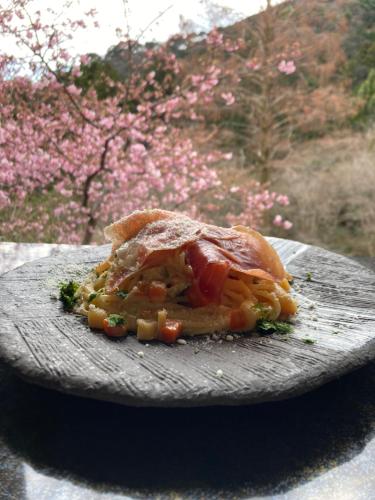 un sándwich sentado en un plato con flores en el fondo en HOTEL LT Kitchen 湯河原, en Yugawara