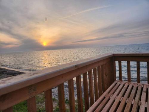 a view of the ocean from a deck with a bench at Bluewater Delight in Sarnia