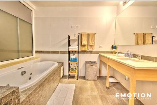 a bathroom with a tub and a sink at Appartement 2 chambres Blue Marine Maho Sxm in Maho Reef