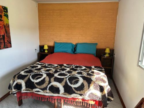 ein Schlafzimmer mit einem Bett mit einer Decke darauf in der Unterkunft Posada campo bello in Quebracho