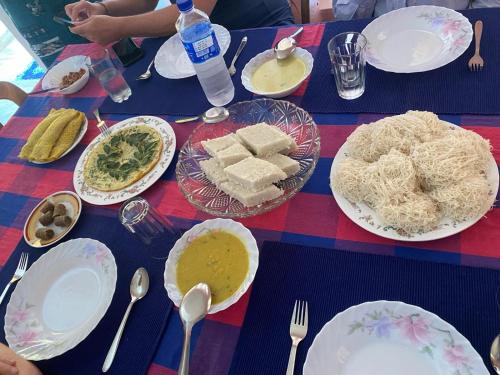 a blue table with plates of food on it at Lodge In The Valley Udawalawa in Udawalawe