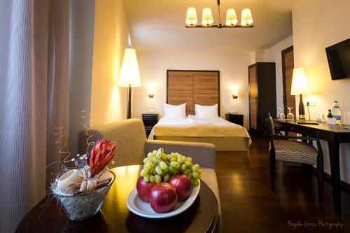 a hotel room with a table with a bowl of fruit at Europa Royale Bucharest in Bucharest