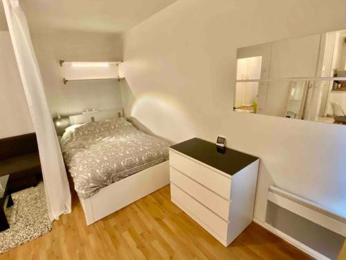 - une petite chambre avec un lit et une commode dans l'établissement Studio CosyLux proche Paris Stade De France, à Saint-Denis