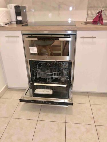 un four avec sa porte ouverte dans une cuisine dans l'établissement Studio CosyLux proche Paris Stade De France, à Saint-Denis