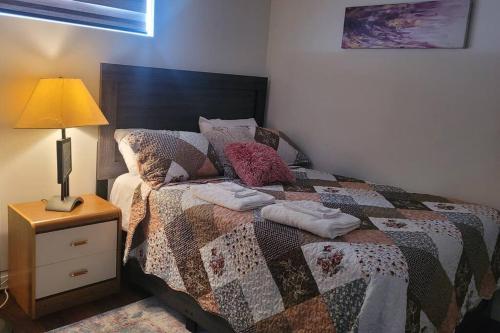 a bedroom with a bed with a quilt on it at Two luxury bedrooms in the basement in Winnipeg