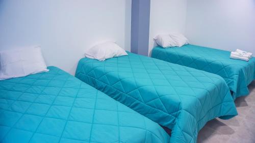 two beds in a room with blue comforter at LAS GAVIOTAS DE PARACAS in Paracas
