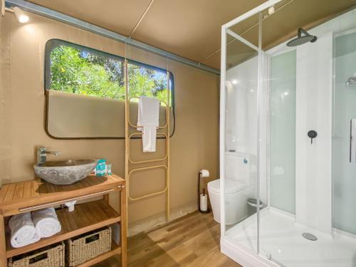ein Bad mit einer Dusche und einem Waschbecken in der Unterkunft Magnetic Glamping Tent 10 in Nelly Bay