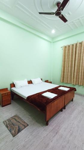 a bedroom with a bed and a ceiling fan at ARJUN PAYING GUEST HOUSE in Ayodhya
