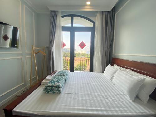 um quarto com uma cama grande e uma janela em UY LONG Homestay & Coffee em Duong Dong