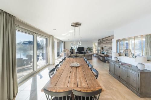 a dining room with a large wooden table and chairs at 10 Bowmoor Edge By Birch Stays in Gloucestershire