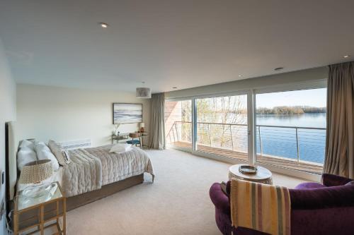 a bedroom with a bed and a large window at 10 Bowmoor Edge By Birch Stays in Gloucestershire