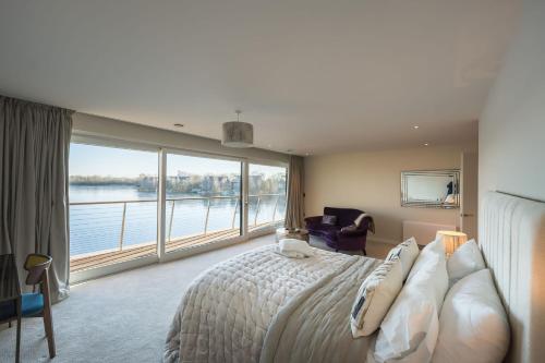 a bedroom with a large bed and a large window at 10 Bowmoor Edge By Birch Stays in Gloucestershire