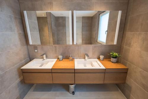 a bathroom with two sinks and a large mirror at 10 Bowmoor Edge By Birch Stays in Gloucestershire