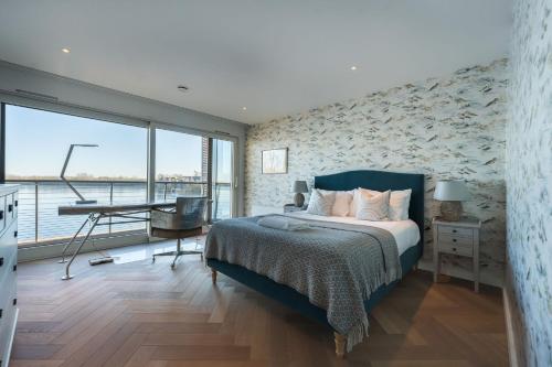a bedroom with a bed and a desk and a window at 10 Bowmoor Edge By Birch Stays in Gloucestershire