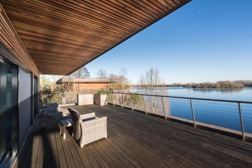 a deck with chairs and a view of the water at 10 Bowmoor Edge By Birch Stays in Gloucestershire