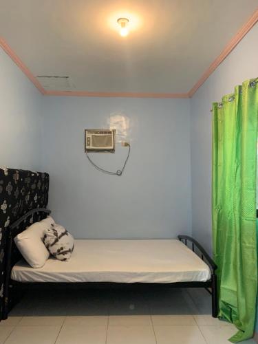 a small room with a bed and a fan at Rebecca Guest in Pooc