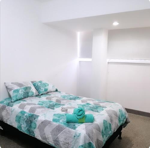 Un dormitorio con una cama con una toalla azul. en Apto moderno zona 1 en Guatemala