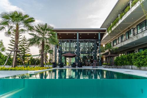 a swimming pool in front of a building at The River Palm Resort in Bang Hia