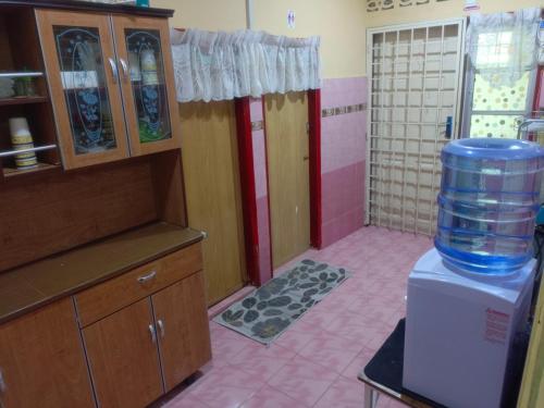 a kitchen with a large water container on top of a refrigerator at MieHomestay Binjai Rendah in Bukit Payong
