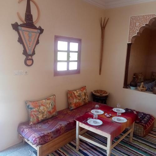 a living room with a table and a couch at Dar Brahim Resto Beds in Ouarzazate