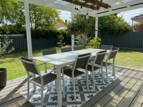 a white table and chairs on a deck at The Miner's Rest in Stawell