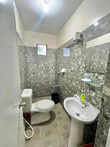 a bathroom with a toilet and a sink at ZAFFIRIAH GUEST HOUSE in Moalboal