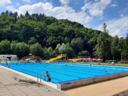 a large swimming pool with people in it at V přírodě na okraji Frenštátu pod Radhoštěm in Frenštát pod Radhoštěm
