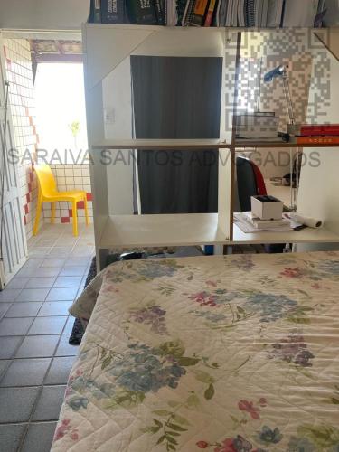 Cette chambre comprend un lit, une table et un bureau. dans l'établissement CASA DE PRAIA AV BEIRA MAR, à Cabo de Santo Agostinho