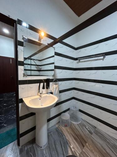 y baño con lavabo y espejo. en AAHI'S CHILAPATA JUNGLE STAY en Fālākāta