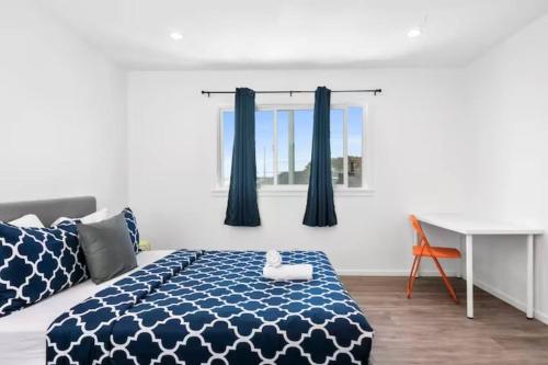 a bedroom with a blue and white bed and a desk at Newly Remodeled Cozy 2BR or 3BR Apartment in Tanforan, block away from CalTrain, near SFO in San Bruno