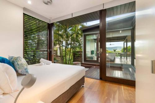 1 dormitorio con cama y ventana grande en 53B Murphy Street - Modern luxury in Port Douglas, en Port Douglas