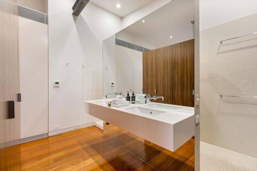y baño blanco con lavabo y ducha. en 53B Murphy Street - Modern luxury in Port Douglas, en Port Douglas