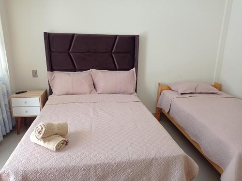 a bedroom with two beds with towels on them at Hotel Sunlight in Paracas