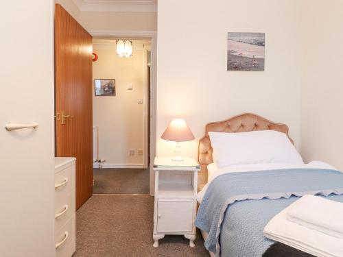 a bedroom with a bed and a table with a lamp at Harbour Side in Maryport