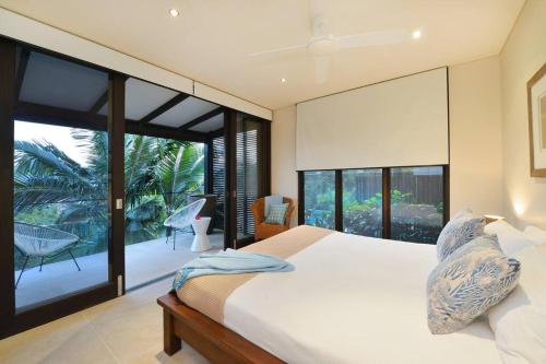 - une chambre avec un grand lit et un balcon dans l'établissement Hapuka - Luxury Villa with Stunning Views on Murphy St, à Port Douglas