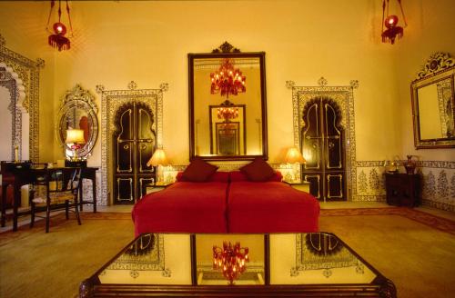 a bedroom with a red bed in a room at Shiv Niwas Palace by HRH Group of Hotels in Udaipur