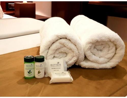 a bathroom with a towel and two products on a table at Hotel White Tree, Chandigarh in Chandīgarh