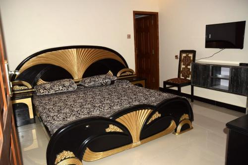 een slaapkamer met een groot bed en een televisie bij Haji Jalaluddin Villa in Lower Topa