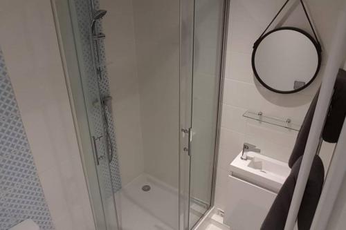 a bathroom with a shower and a sink and a mirror at Studio Port Cergy in Cergy