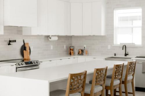 a kitchen with a white counter top and wooden chairs at Moses Lake Golf Retreat @ Resorts At Moses Pointe in Moses Lake