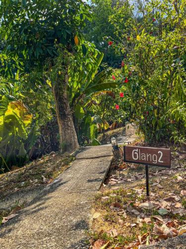 a sign on the side of a road with trees at Hillhouse - Koh Yao Noi in Ko Yao Noi