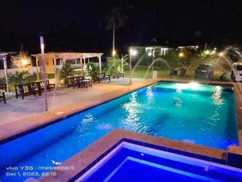 una piscina en un patio por la noche en Casa James Apartment, Rooms , Pool and Restaurant, en Siquijor